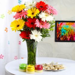 Holi Sweets and Gujiyas - Gerberas vase with Kaju sweets and Holi colors